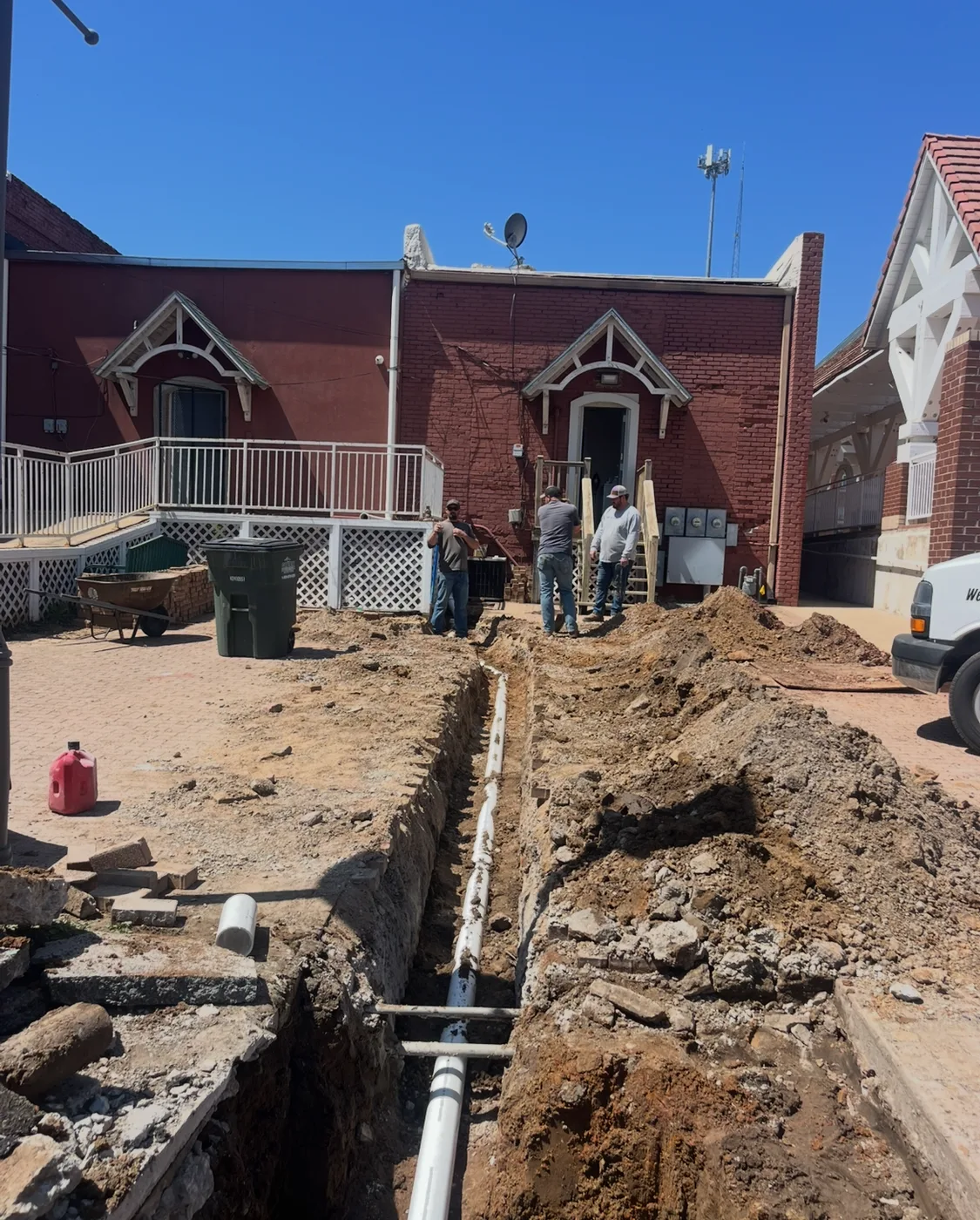 Replacement sewer line in a trench leading toward a building
