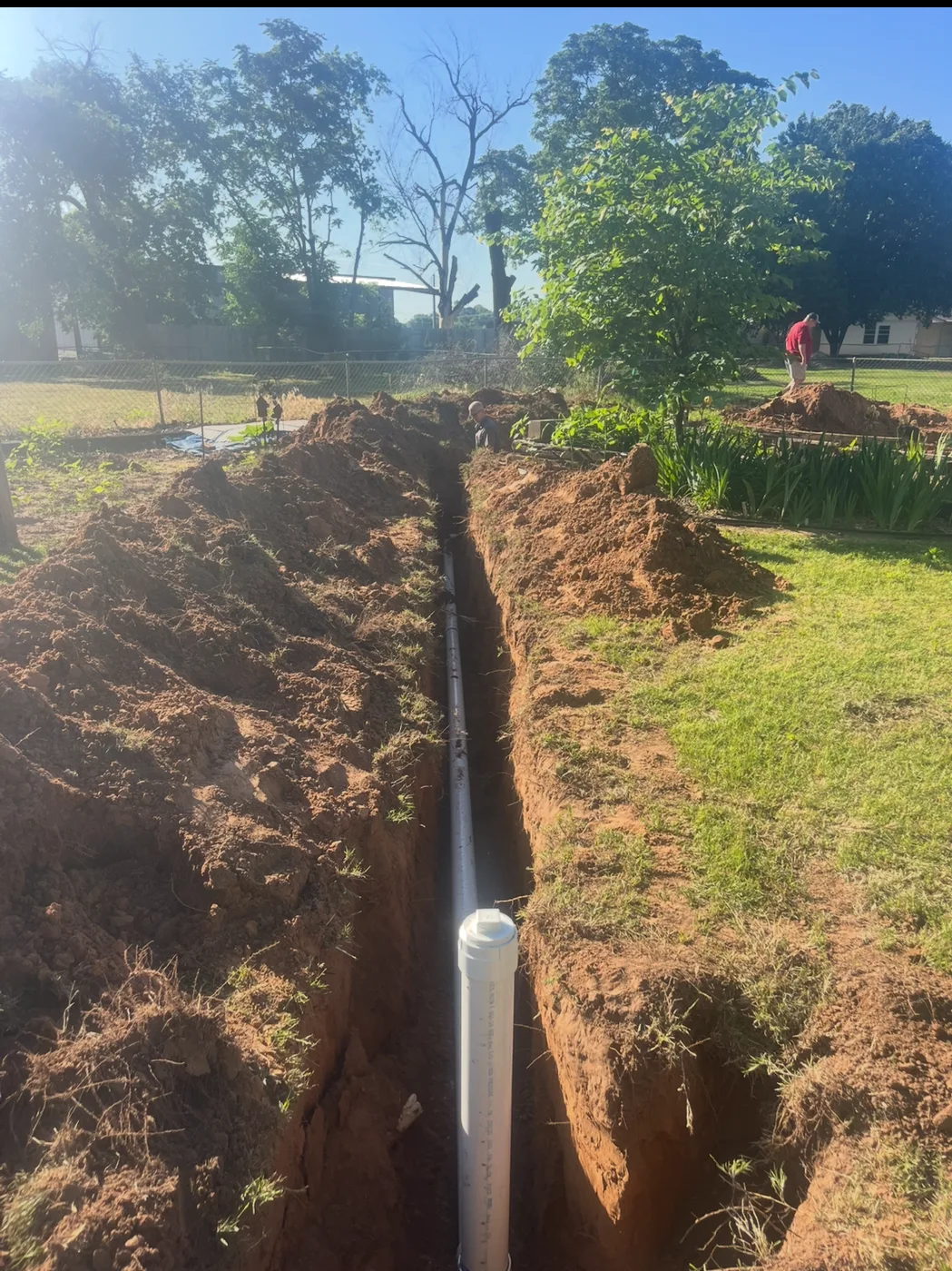 Sewer line and cleanout installed in a yard trench