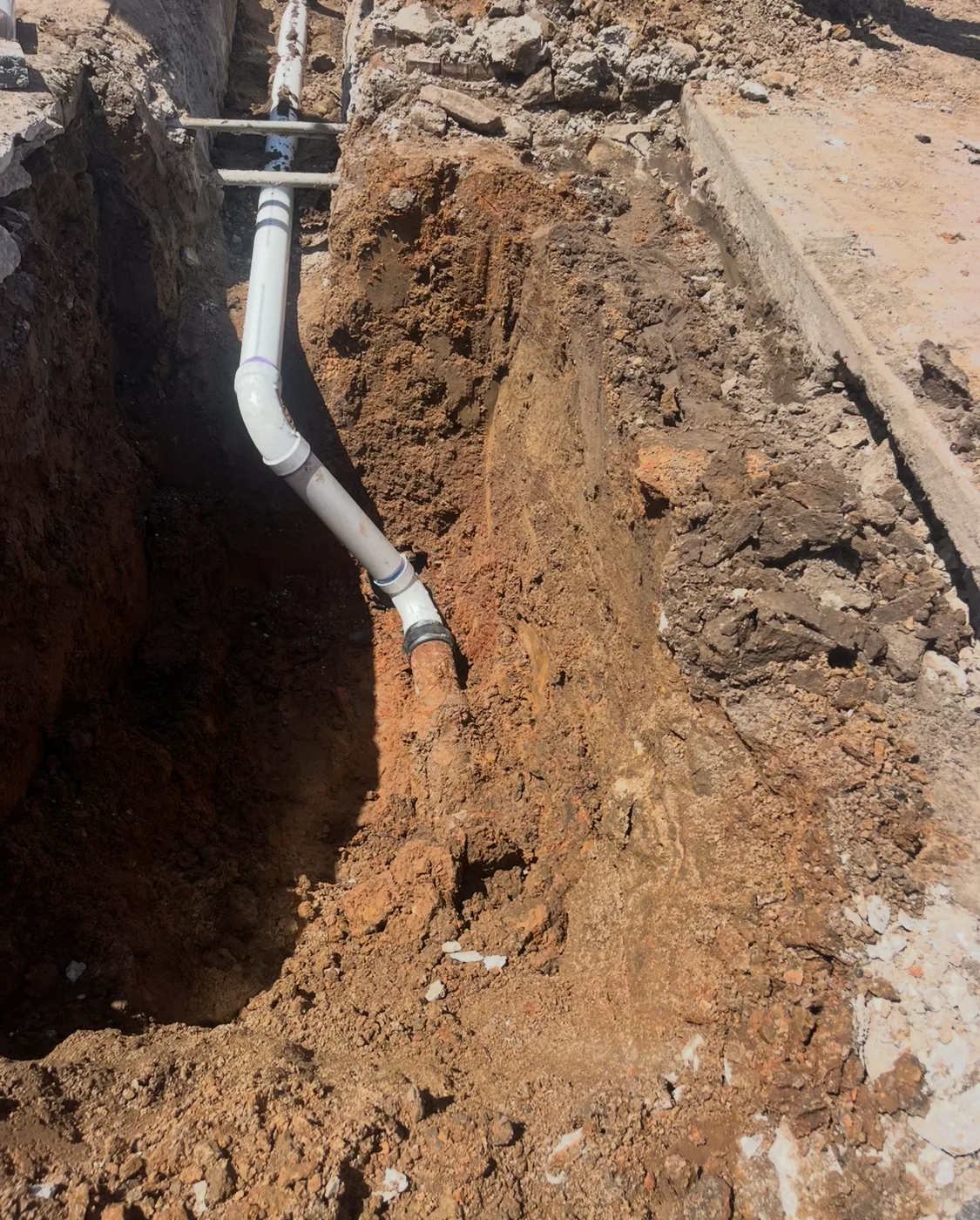 PVC sewer-pipe connection exposed in a repair trench