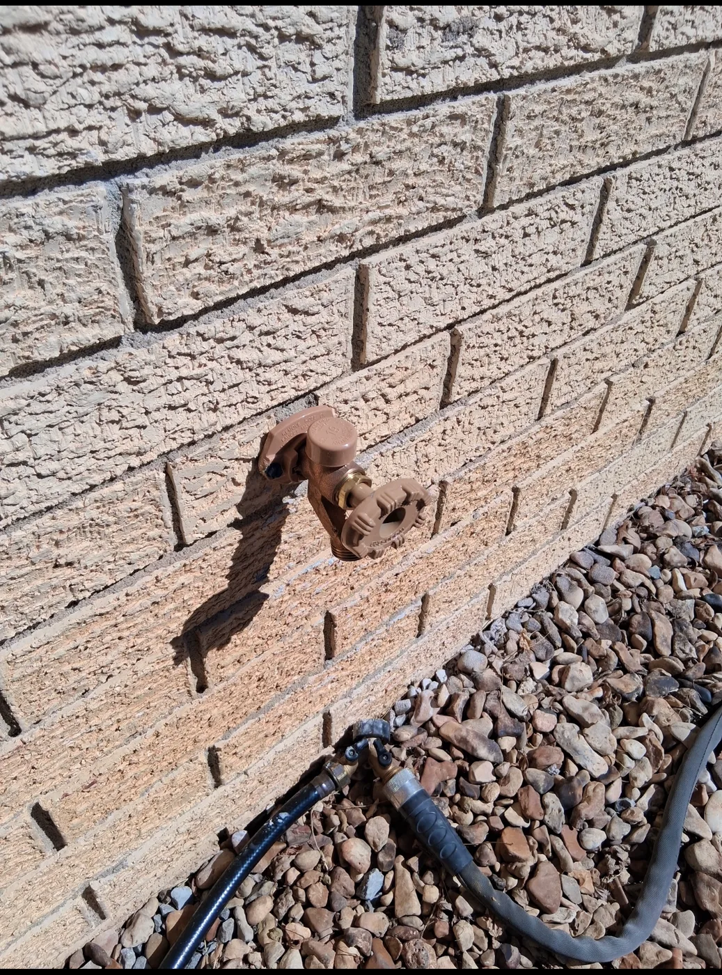 Exterior hose bib mounted on a brick wall